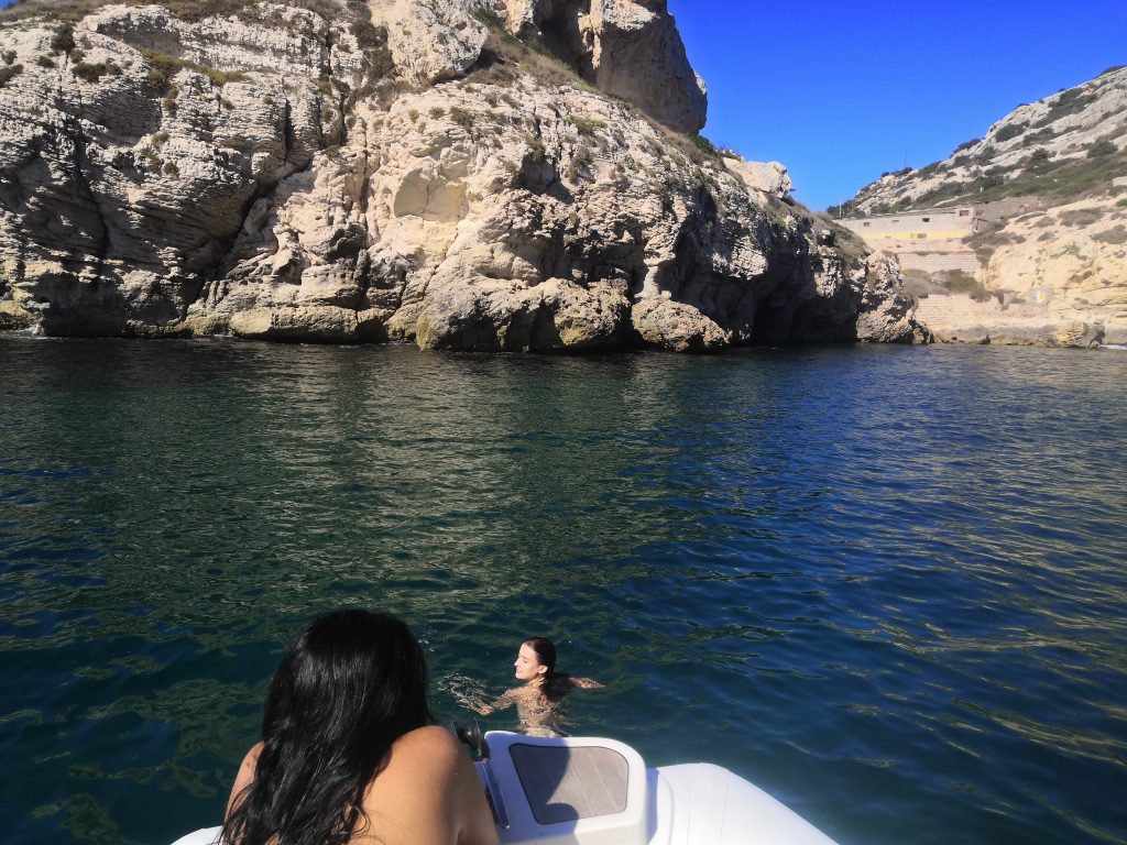 Swimming in crystal clear water below the Devil’s Saddle during a boat tour in Cagliari